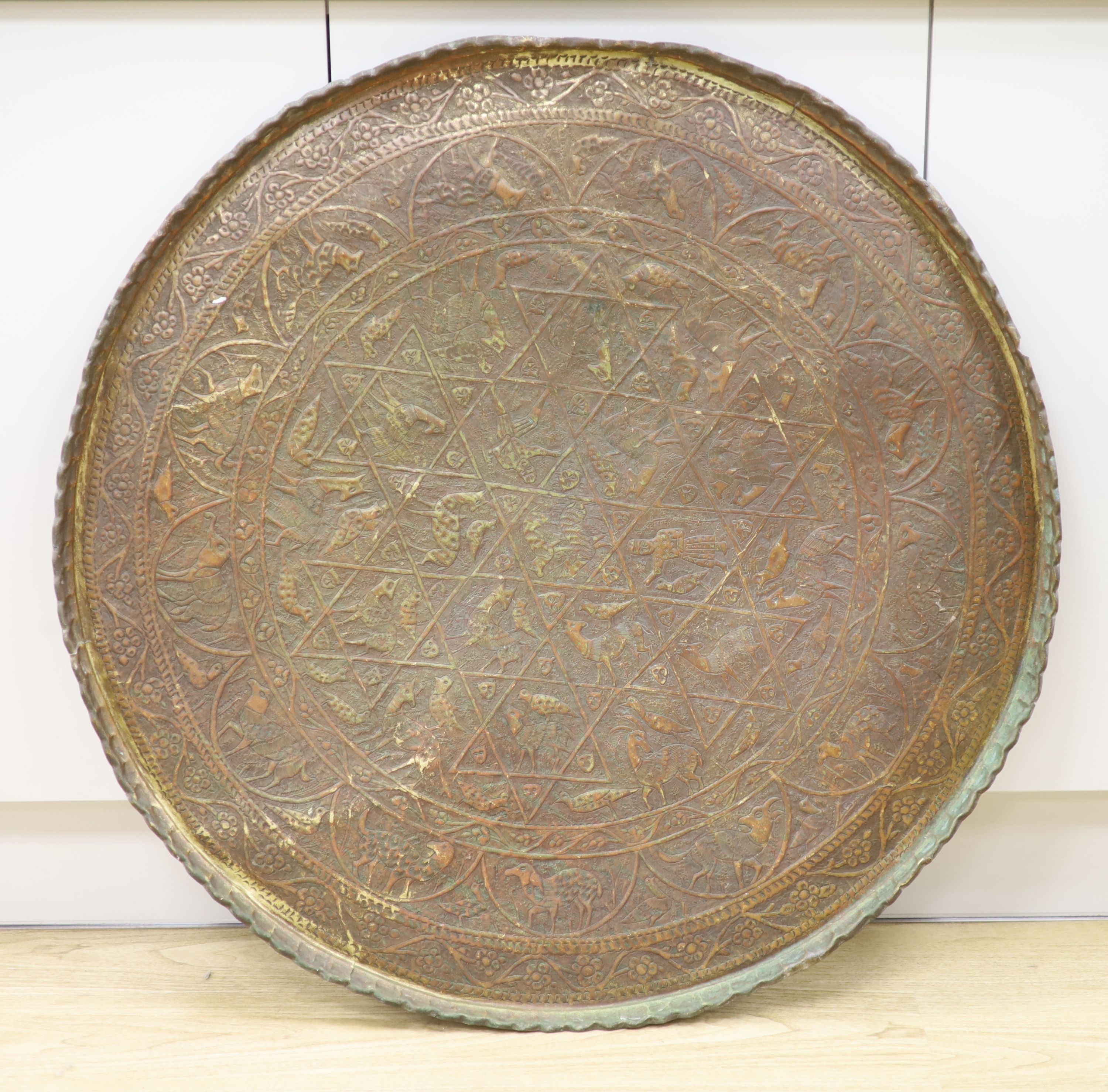 A large Persian engraved brass tray, 86cm diameter